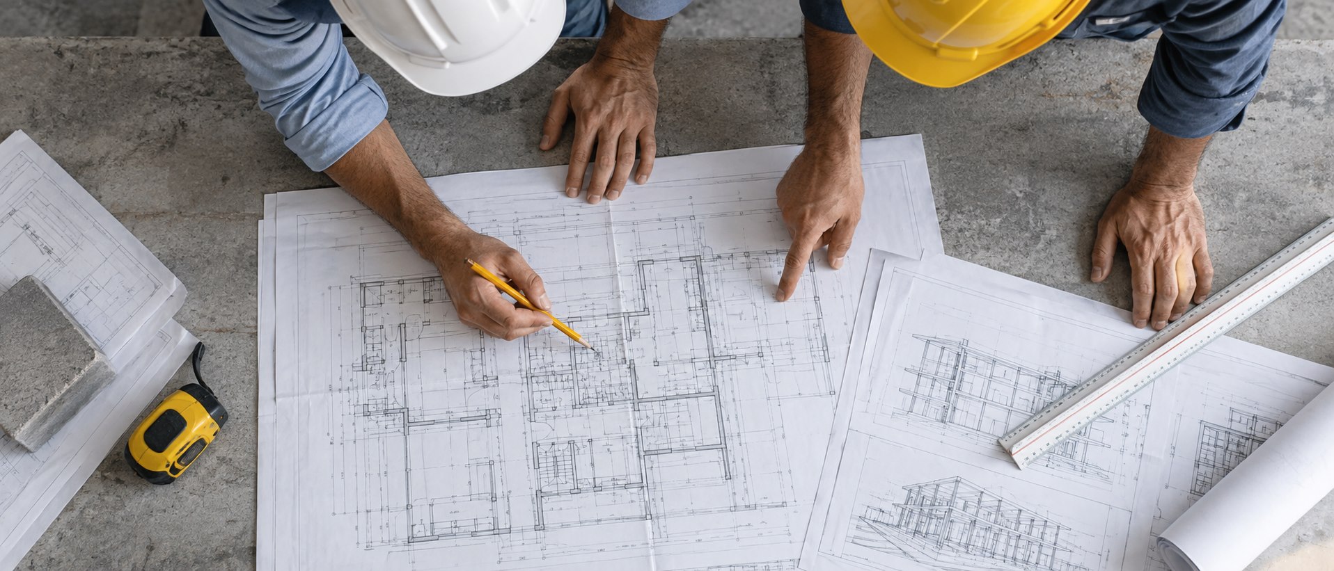 Dois engenheiros analisam plantas técnicas